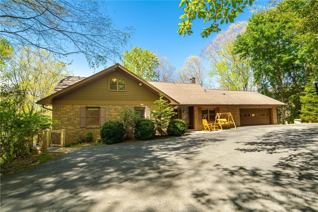 Front of 239 Eagle Drive: stained wood, a broad shingled gable, and the drive under the trees.